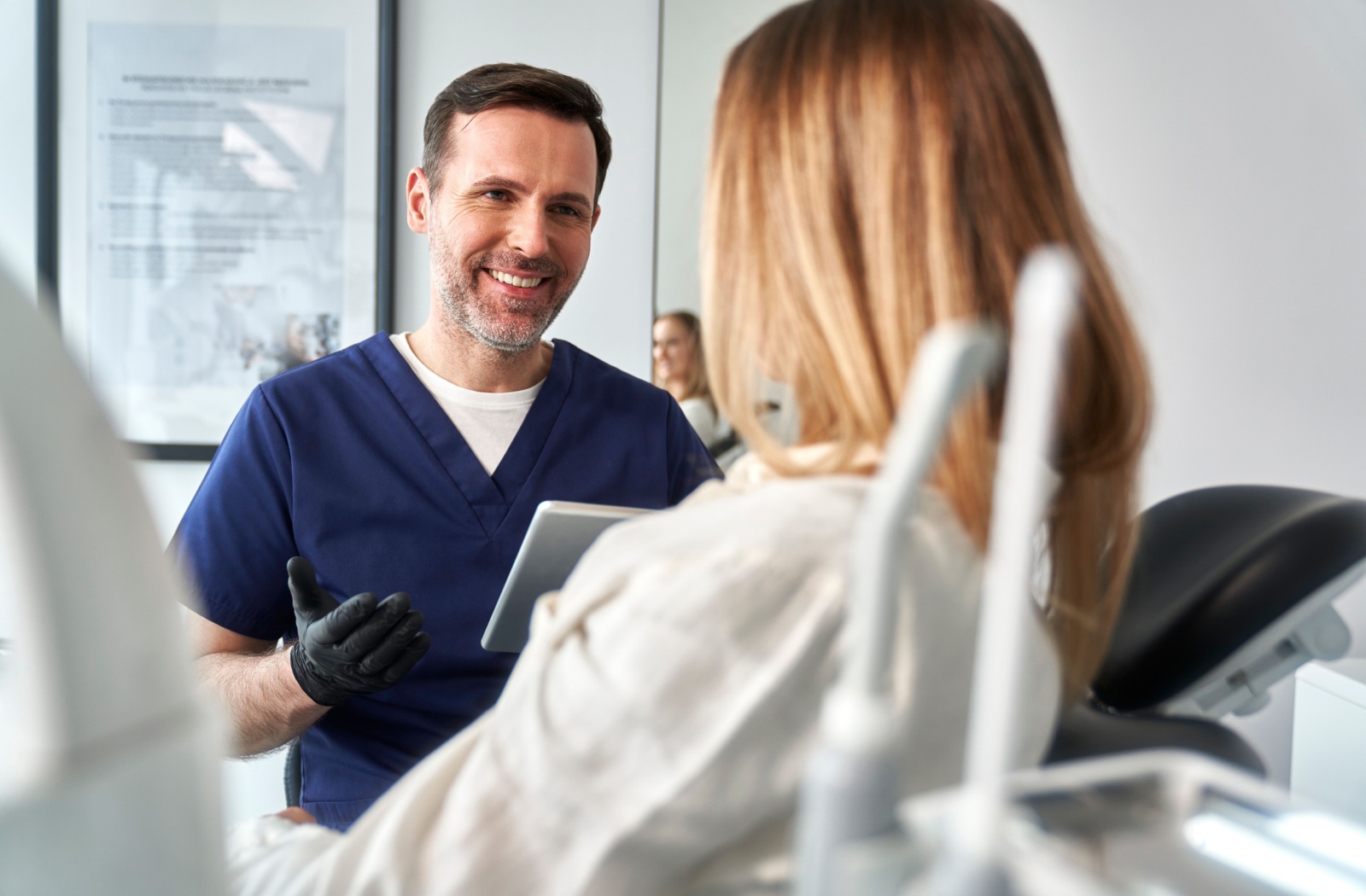 A biological dentist consulting with a new patient at a holistic health focussed dentist's office.